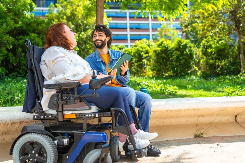 A support coordinator discussing an NDIS plan with a client in a bright office.